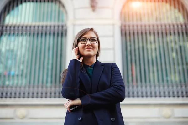 Beautiful female student in a dark stylish stands on the background of the university — Stock Photo, Image