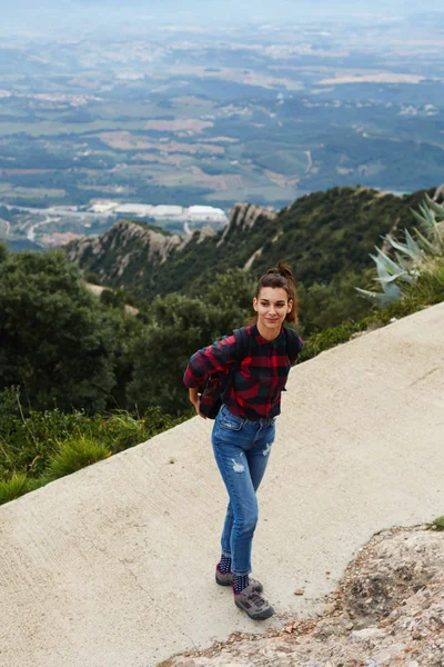 A girl stands on the top of the slope next to the abyss from which a beautiful view — Stock Photo, Image