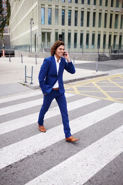 Jeune homme marchant et parlant au téléphone — Photo