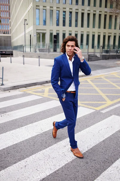 Young man walking and talking on phone — Stock Photo, Image