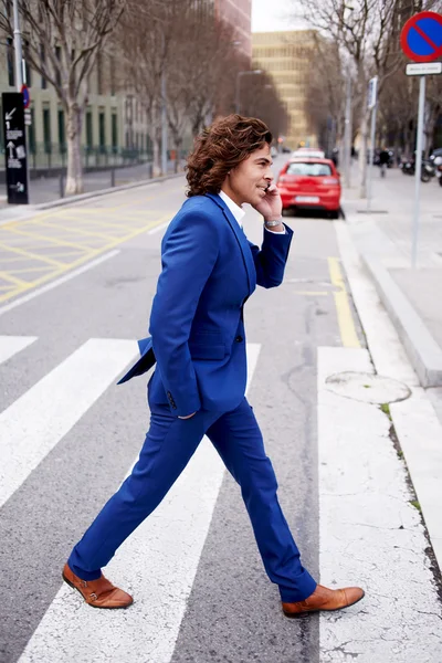 Young man walking and talking on phone — 스톡 사진