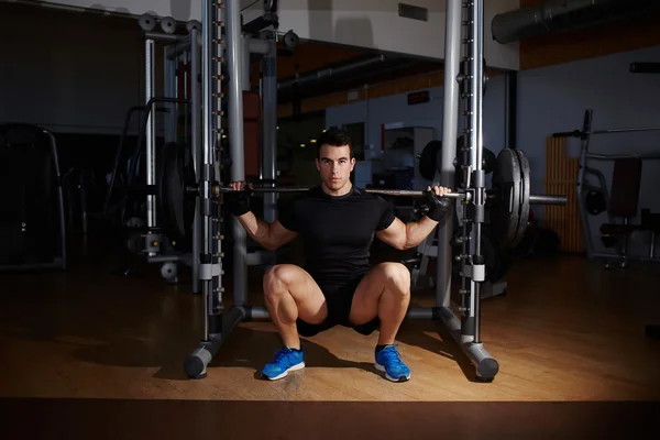 Culturista haciendo ejercicio haciendo sentadillas — Foto de Stock