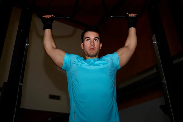 Athlete doing pull up exercise at gym — Stock Photo, Image