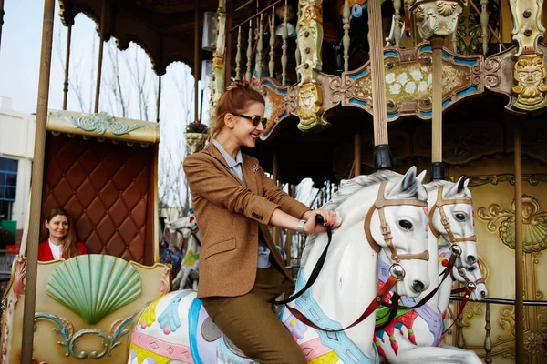Woman riding on a merry go round — Stok fotoğraf