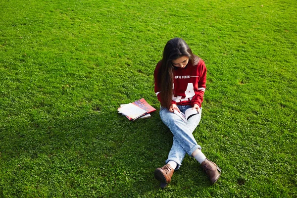 Kvinnlig student sitter med bok — Stockfoto