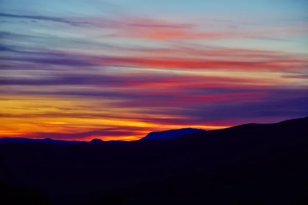 Pôr-do-sol colorido e silhueta de montanha — Fotografia de Stock