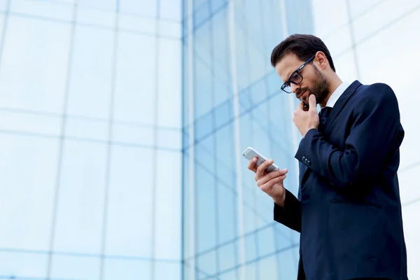 Hombre de negocios sosteniendo teléfono móvil — Foto de Stock