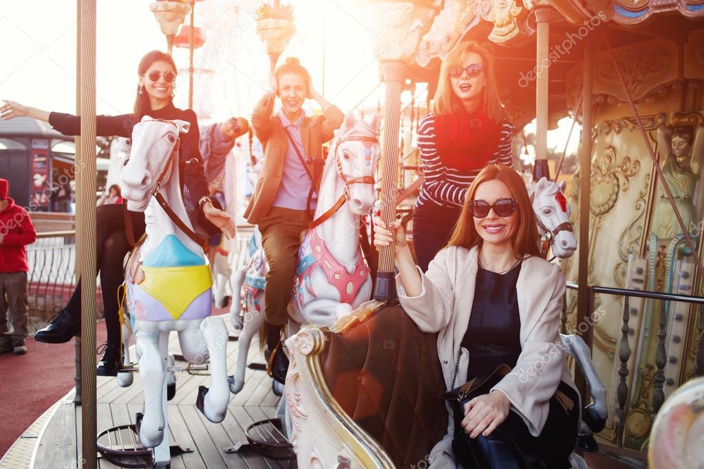 women riding on carousel in amusement park