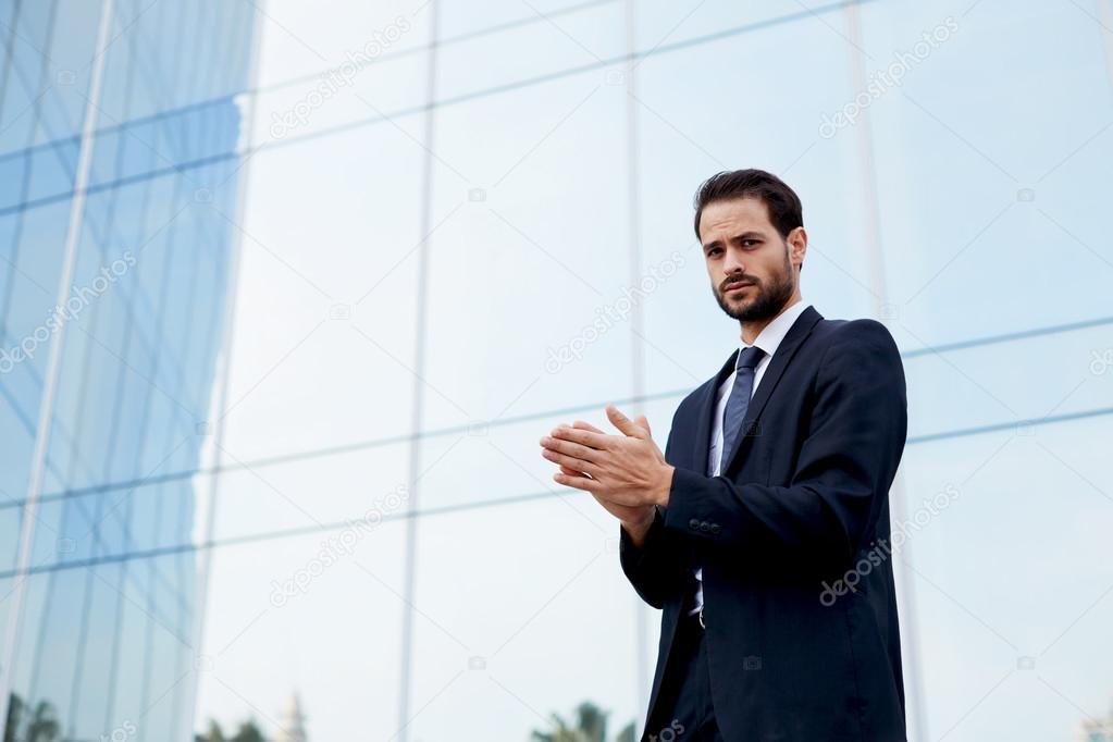 businessman in suit rubs his hands