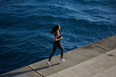 young woman running along the seashore