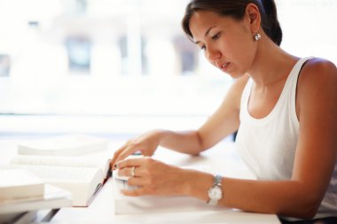Asyalı öğrenci ile açık kitap oturan