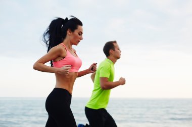 couple  working out on the beach clipart