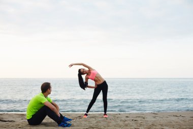 onun erkek arkadaşı alarak mola sırasında fiziksel streç egzersiz yaparak genç fitness kadın