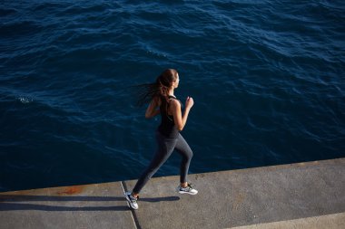 Okyanus dalgaları arka plan üzerinde çalıştıran eylem spor kızla dinamik resim