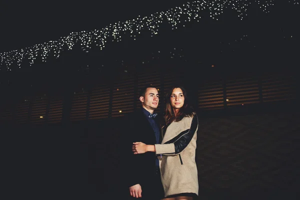 She put her arms around her boyfriend they walk around the city at night — Stock Photo, Image