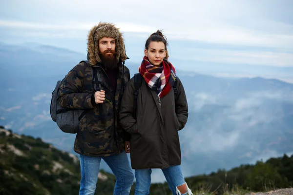 Randonneurs debout au sommet d'une montagne contre la vallée brumeuse — Photo