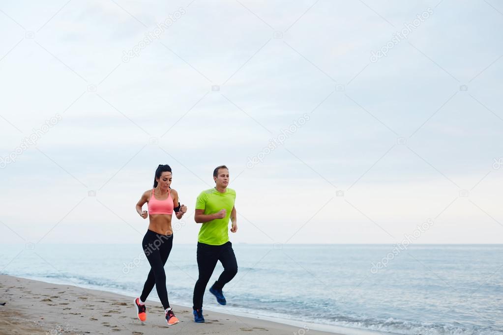 young couple running along the beach