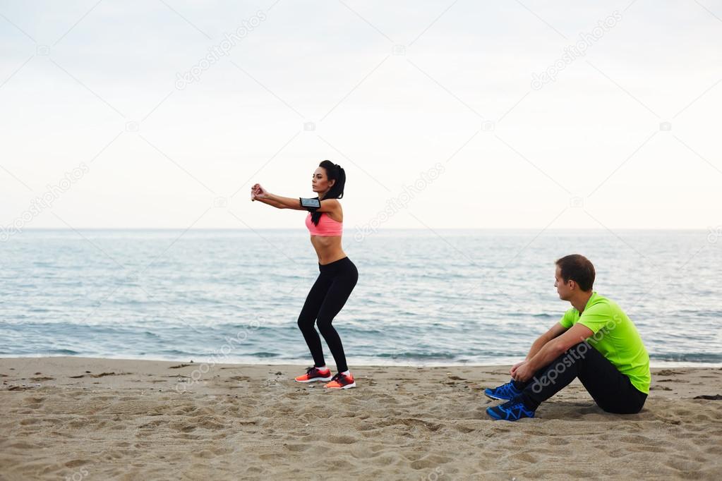 The coach holds training for pervonsalnuyu girl on the beach