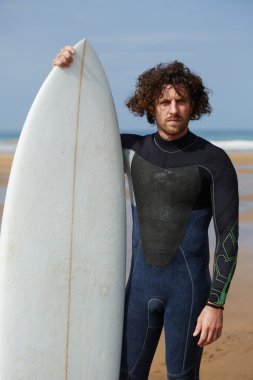 Erkek sörfçü sahilde poz