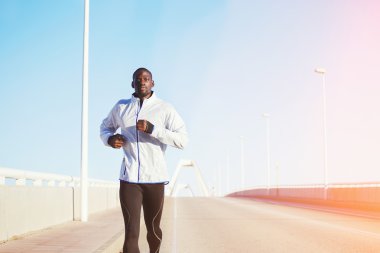 Bir köprü yolda koşan atletik adam