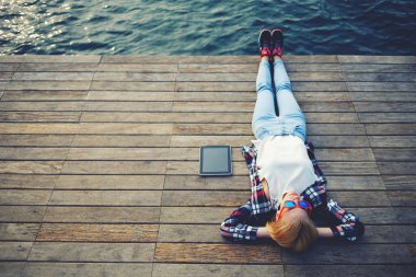Woman lying on a wooden jetty clipart