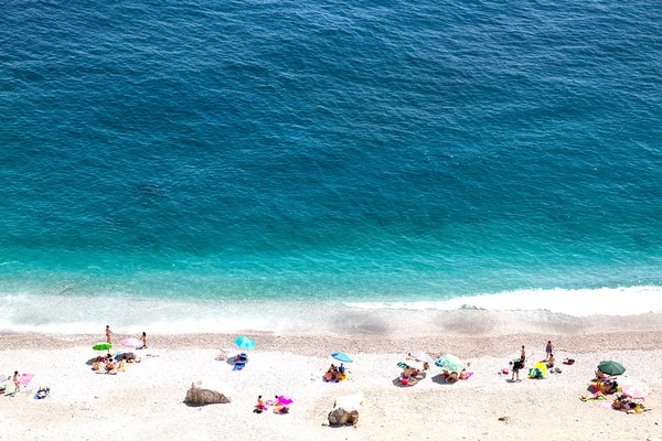 Piękny pobrzeże z ludźmi, zażyć kąpieli słonecznej — Zdjęcie stockowe