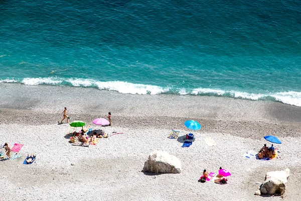 Beautiful seashore with sunbathe people — Stock Photo © GaudiLab #69200489