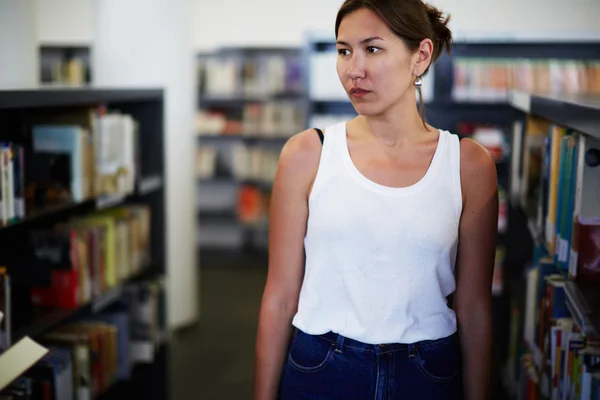 Asiatico femmina in piedi vicino librerie — Foto Stock