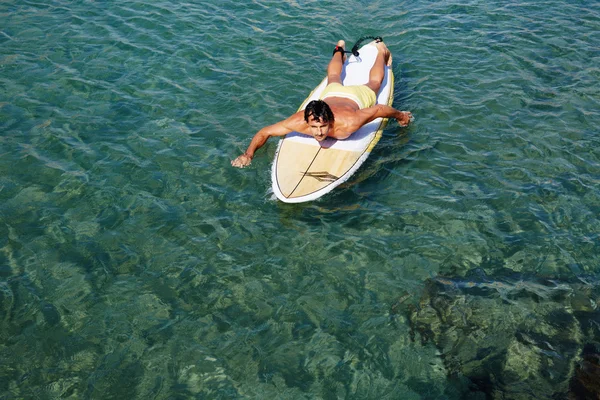 Man genieten van een surf in helder blauw water — Stockfoto