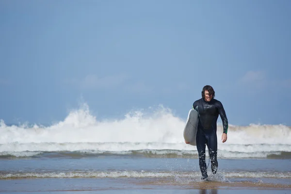 Hombre cargando su tabla de surf — Foto de Stock