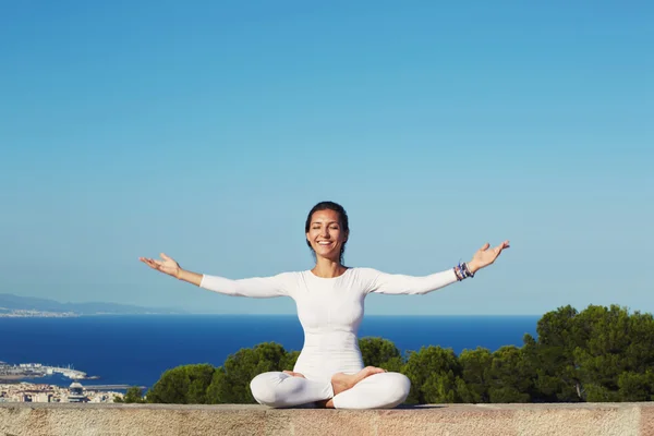 Lächelnde Frau praktiziert Yoga — Stockfoto