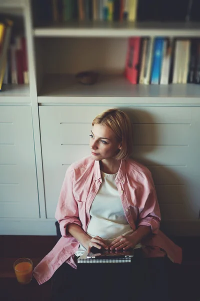 Woman sitting at home bookshelf — Stock Photo, Image