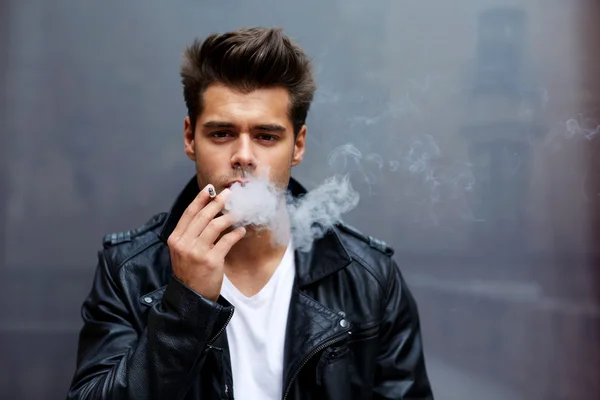 Человек, выдыхающий сигаретный дым — стоковое фото