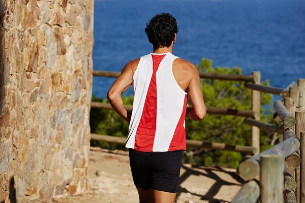 Hombre corriendo por sendero de montaña — Foto de Stock