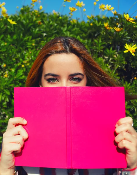 Mujer joven con libro rosa — Foto de Stock