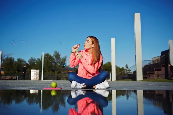 Woman blowing soap bubbles — Stock Photo, Image