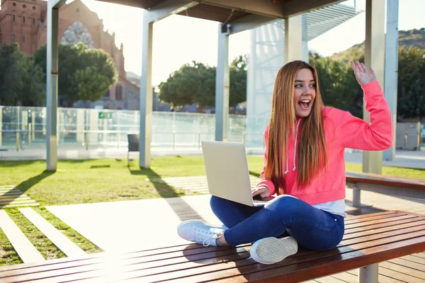 Female student waving to someone — Stock Photo, Image