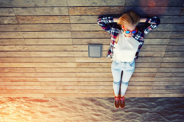 Woman lying on a wooden jetty — Stock Photo, Image