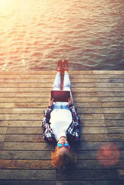 Mujer relajándose sobre un embarcadero de madera — Foto de Stock