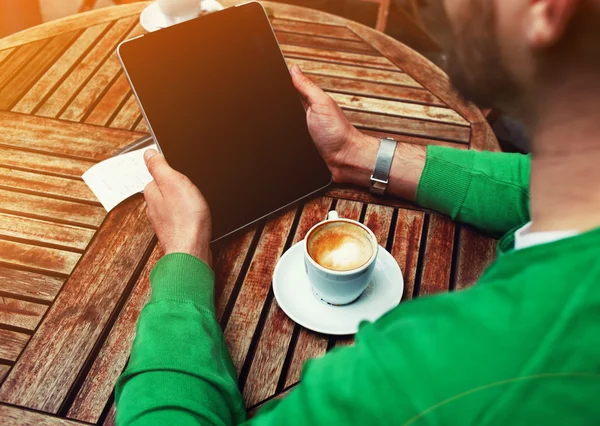 Homme assis à la table avec une tasse de café — Photo