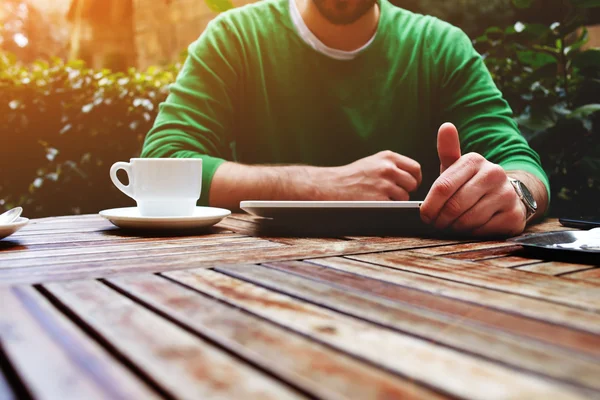 Чоловік сидить за столом з чашкою кави — стокове фото