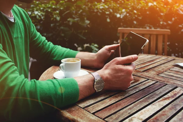 Freelancer zitten op het terras met kop koffie — Stockfoto