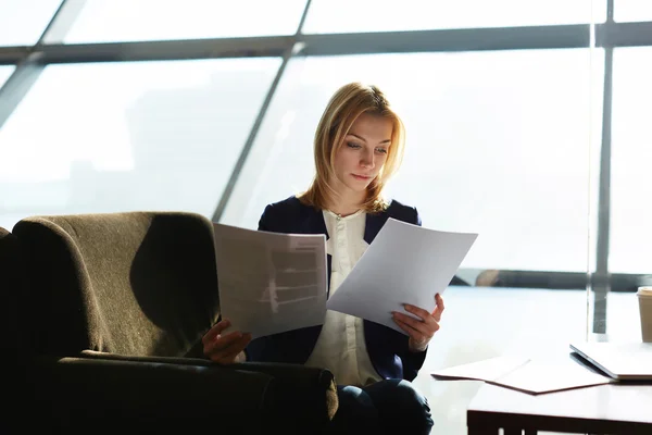 Businesswoman examining paperwork at her desk — Stock Photo, Image