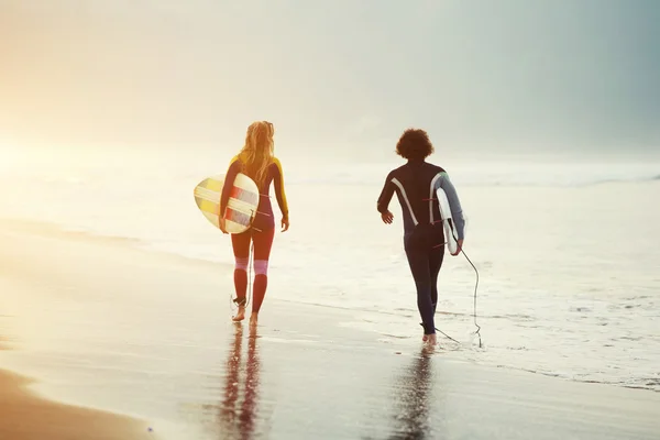 Young couple in wetsuits walking — Stock Photo, Image