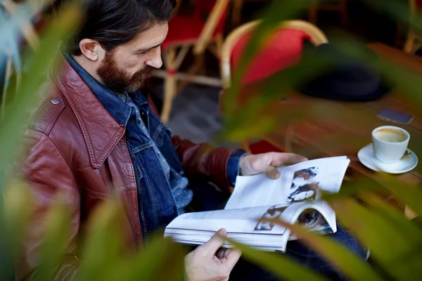 Seorang pria membaca majalah sambil minum kopi — Stok Foto