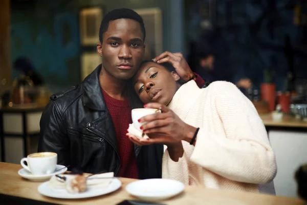 Pareja de piel oscura sentada en una cafetería — Foto de Stock