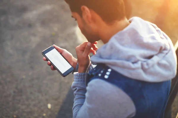 Man met telefoon terwijl permanent buitenshuis Stockfoto