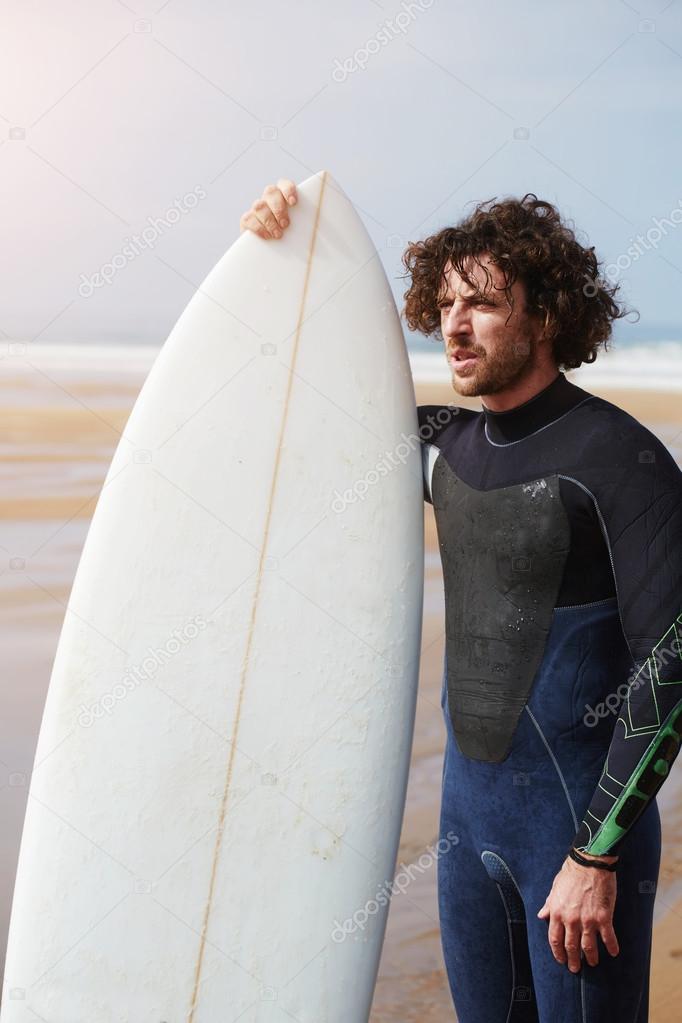 Man with long hair holding surf board