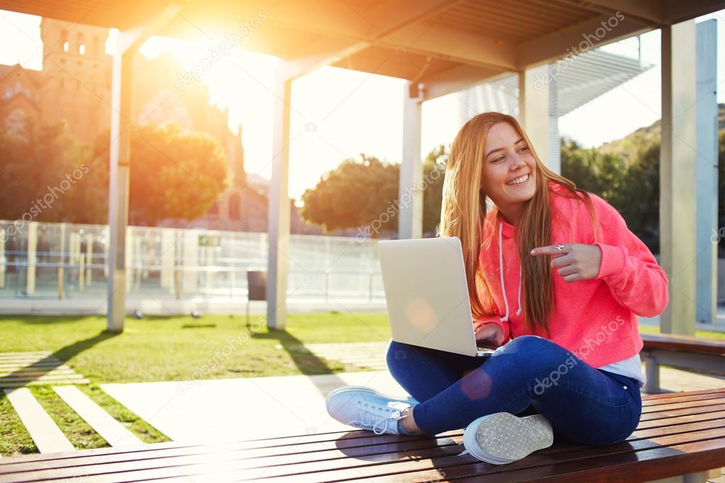 Female student pointing to open laptop