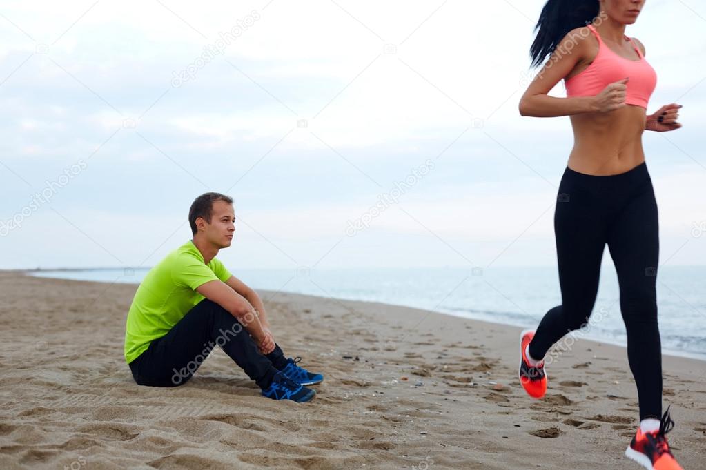 Couple working out against the sea